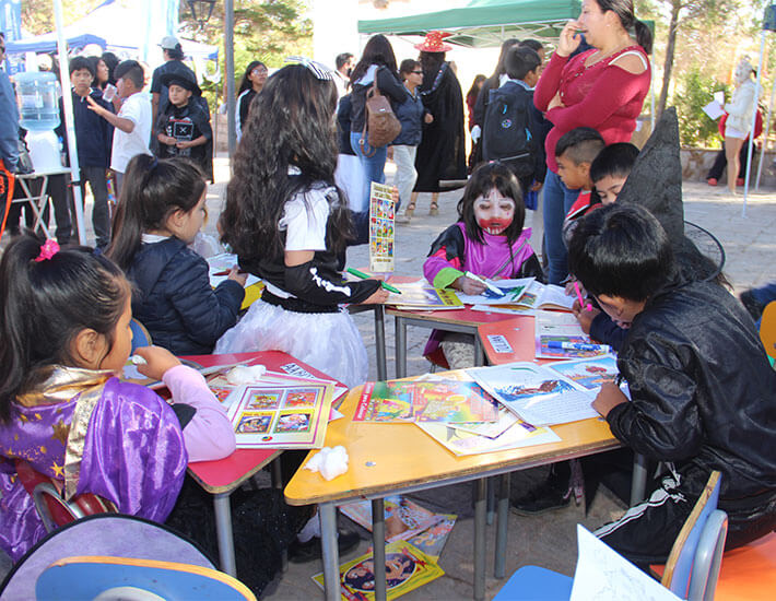 Niños leyendo y pintando que representan educación y cultura en comunidades locales